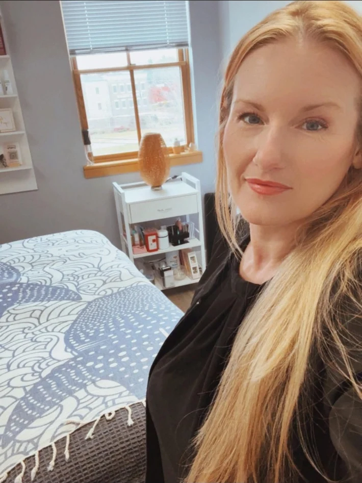 Elina standing beside the treatment bed in her Scarborough studio